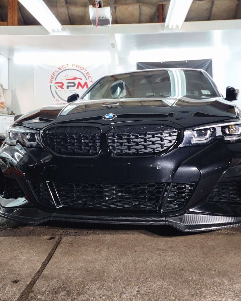 Black BMW 3 Series with a deep gloss finish in the RPM Auto Spa garage